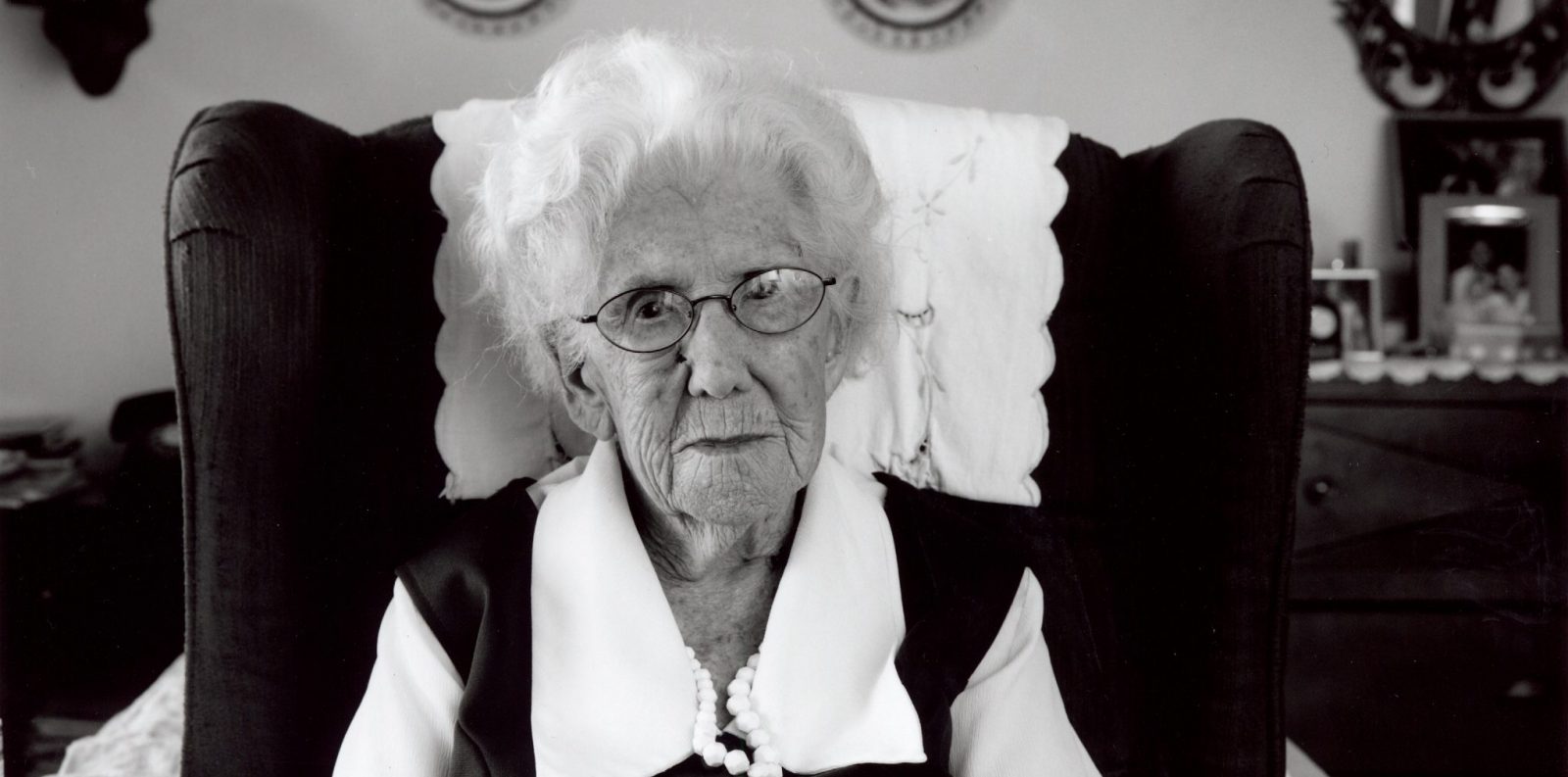 Senior Female sitting in Wing back chair